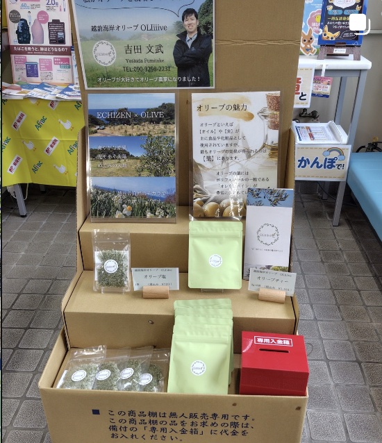 無人販売棚に並ぶオリーブ商品